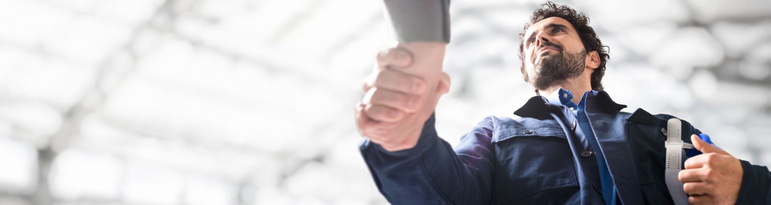 Ein Ingenieur schüttelt seinem Arbeitgeber die Hand. 