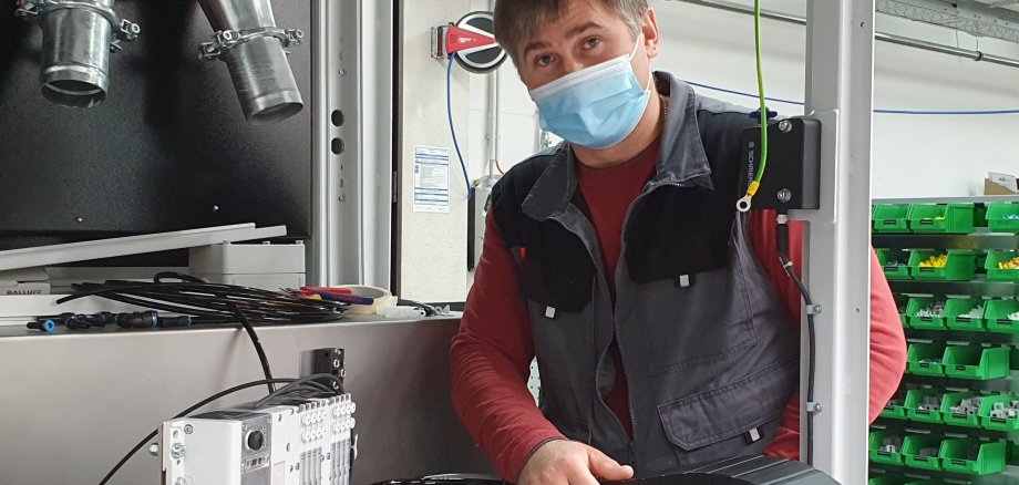 Ein Elektroniker für Betriebstechnik bei seiner Arbeit im Sondermaschinenfertigbau