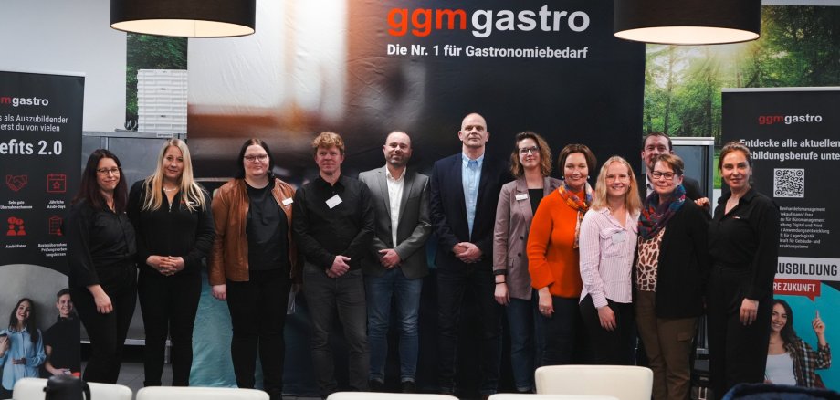 Christa Lendrich, Bürgermeisterin der Stadt Ochtrup (5. von rechts) und Vertreter des Unternehmens GGM Gastro, der Wirtschaftsförderung Ochtrup, der Agentur für Arbeit und des jobcenters Kreis Steinfurt zogen ein positives Fazit von der gemeinsam organisierten Betriebsbesichtigung. 􀀮􀁇􀁐􀁆􀁔􀁋􀁅􀁊􀀎 􀀤􀃘􀁔􀁉􀁇􀁔􀁏􀁇􀁋􀁕􀁖􀁇􀁔􀁋􀁐 􀁆􀁇􀁔 􀀵􀁖􀁃􀁆􀁖 􀀱􀁅􀁊􀁖􀁔􀁗􀁒 􀀊􀀗􀀐􀁘􀀐􀁔􀀐􀀋􀀎 􀁕􀁑􀁙􀁋􀁇 􀀸􀁇􀁔􀁖􀁔􀁇􀁖􀁇􀁔􀁋􀁐􀁐􀁇􀁐 􀁗􀁐􀁆 􀀸􀁇􀁔􀁖􀁔􀁇􀁖􀁇􀁔 􀁆􀁇􀁕 􀀷􀁐􀁖􀁇􀁔􀁐􀁇􀁊􀁏􀁇􀁐􀁕 􀀩􀀩􀀯 􀀩􀁃􀁕􀁖􀁔􀁑􀀎 􀁆􀁇􀁔 􀀹􀁋􀁔􀁖􀁕􀁅􀁊􀁃􀁈􀁖􀁕􀁈􀃒􀁔􀁆􀁇􀁔􀁗􀁐􀁉 􀀱􀁅􀁊􀁖􀁔􀁗􀁒􀀎 􀁆􀁇􀁔 􀀣􀁉􀁇􀁐􀁖􀁗􀁔 􀁈􀃘􀁔 􀀣􀁔􀁄􀁇􀁋􀁖 􀁗􀁐􀁆 􀁆􀁇􀁕 􀀬􀁑􀁄􀁅􀁇􀁐􀁖􀁇􀁔􀁕 􀀭􀁔􀁇􀁋􀁕 􀀵􀁖􀁇􀁋􀁐􀁈􀁗􀁔􀁖 􀁜􀁑􀁉􀁇􀁐 􀁇􀁋􀁐 􀁒􀁑􀁕􀁋􀁖􀁋􀁘􀁇􀁕 􀀨􀁃􀁜􀁋􀁖 􀁘􀁑􀁐 􀁆􀁇􀁔 􀁉􀁇􀁏􀁇􀁋􀁐􀁕􀁃􀁏 􀁑􀁔􀁉􀁃􀁐􀁋􀁕􀁋􀁇􀁔􀁖􀁇􀁐 􀀤􀁇􀁖􀁔􀁋􀁇􀁄􀁕􀁄􀁇􀁕􀁋􀁅􀁊􀁖􀁋􀁉􀁗􀁐􀁉􀀐