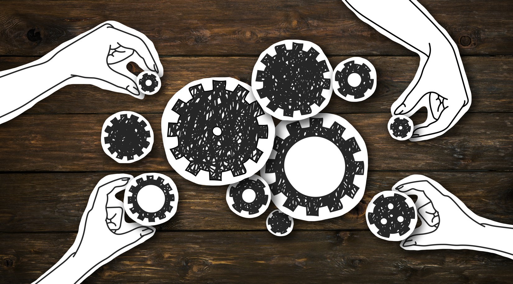 Paper hands collecting gears, creating whole mechanism