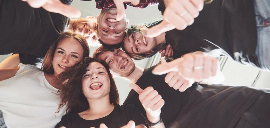 Happy group of friends with their hands together in the middle